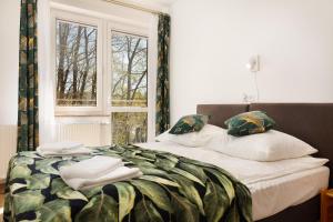 a bedroom with a bed with pillows and a window at Dobra Miejscówka in Krynica Zdrój