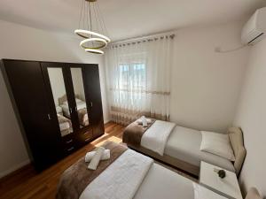 a bedroom with two beds and a couch and a mirror at White Hill in Ulcinj