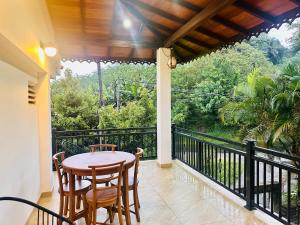 a patio with a table and chairs on a balcony at Goldern Gate in Kandy