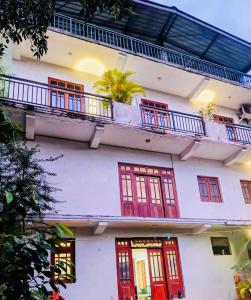 a white building with red windows and a balcony at Goldern Gate in Kandy +27 photos