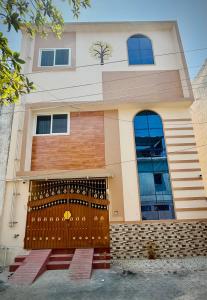 a house with a wooden gate in front of it at Ayaf Homes in Pondicherry