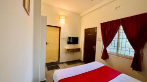 a bedroom with a bed and a tv and a window at Ayaf Homes in Pondicherry +23 photos