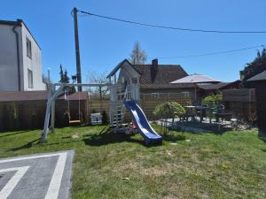 a playground with a slide in a yard at Noclegi Piaskowa 44 in Nowa Karczma