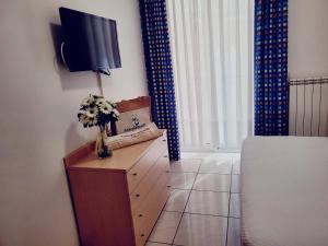 a living room with a tv and flowers on a table at Casa Lucia 2 - Sottomarina in Sottomarina +3 photos
