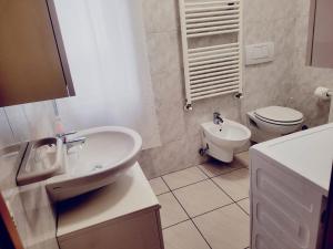 a white bathroom with a toilet and a sink at Casa Lucia 2 - Sottomarina in Sottomarina
