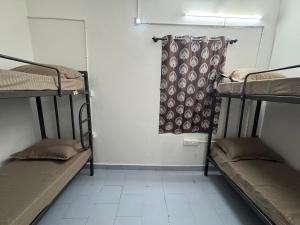 a room with three bunk beds and a curtain at Udupi Shri Krishna Dormitary Bed Space in Udupi +5 photos