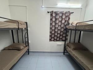 a room with three bunk beds and a curtain at Udupi Shri Krishna Dormitary Bed Space in Udupi