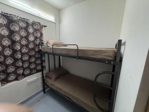 a room with two bunk beds and a curtain at Udupi Shri Krishna Dormitary Bed Space in Udupi