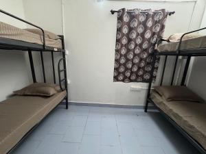 a room with two bunk beds and a window at Udupi Shri Krishna Dormitary Bed Space in Udupi