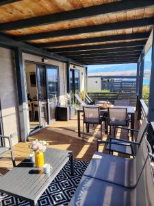 a patio with tables and chairs on a balcony at Izzi Mobile Home - Terra Park SpiritoS in Kolan