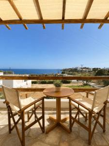 a table and chairs on a patio with a view of the ocean at Agnadi Syros Beachfront Studios & Rooms in Megas Gialos - Nites