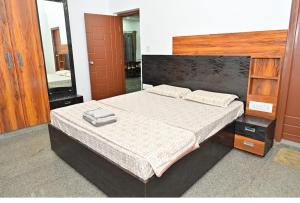 a bedroom with a large bed and a mirror at Relaxing Villa in Mysuru! in Mysore
