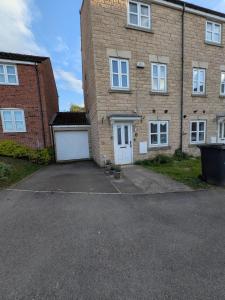 a large brick building with two white garage doors at Large Modern House With Private Parking in Heeley