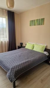 a bedroom with a bed with a blue comforter and a window at Belogradchik View Apartment in Belogradchik +13 photos