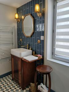 a bathroom with a sink and a mirror and a stool at La Georginette in Saint-Georges-sur-Cher +53 photos