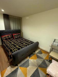 a bedroom with a black bed with a checkered floor at Cosy Room in Richmond
