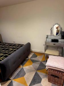 a bedroom with a bed and a mirror and a table at Cosy Room in Richmond
