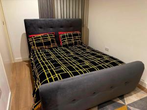 a bed with black and yellow sheets and pillows at Cosy Room in Richmond