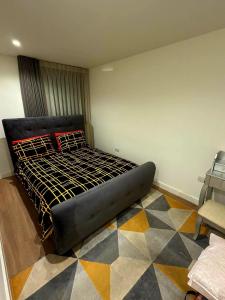 a bedroom with a black bed with a geometric floor at Cosy Room in Richmond