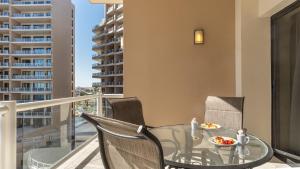 a balcony with a glass table and chairs on a balcony at Las Palomas Beach & Golf Resort - One Bedroom Condos in Puerto Peñasco