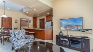a living room with a tv on a wall at Las Palomas Beach & Golf Resort - One Bedroom Condos in Puerto Peñasco