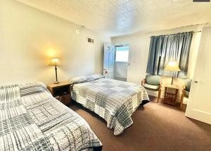 a hotel room with two beds and a chair at Flora Motel in Flora
