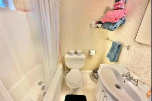 a bathroom with a toilet and a tub and a sink at Flora Motel in Flora +16 photos