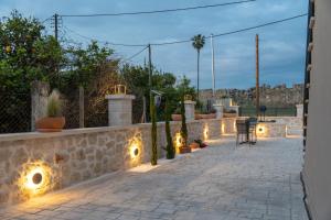 a patio with lights and a stone wall at Antaia 1 in Nafplio