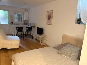 a living room with a bed and a kitchen with a table at Marne appartements in Nogent-sur-Marne
