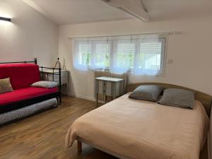 a bedroom with a bed and a red couch at Marne appartements in Nogent-sur-Marne