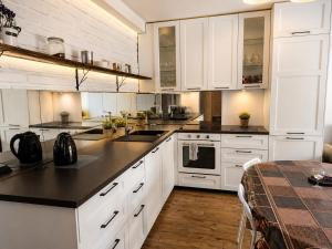 a kitchen with white cabinets and a black counter top at 3 Rooms Garden Parking in Raszyn +5 photos