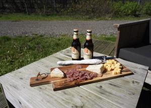 Zwei Flaschen Wein auf einem Tisch mit Käse und Fleisch in der Unterkunft F1 Spa 2026 Circuit 2p Parking Dopey in Amel