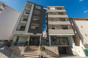an apartment building with stairs in front of it at Garni Hotel MB Premium in Budva