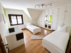 a white bedroom with a bed and a couch at Sweet&City HOUSE in Saint-Vith