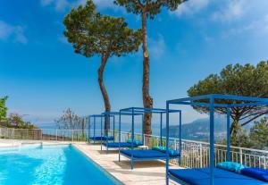 a swimming pool with blue chairs next to trees at Residence Le Terrazze in Sorrento