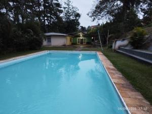 a large blue swimming pool in a yard at Chácara Volito in Cotia