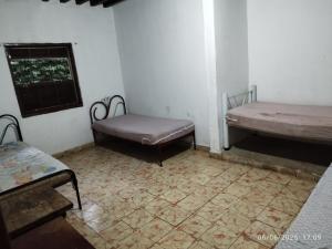 an empty room with two beds and a window at Chácara Volito in Cotia