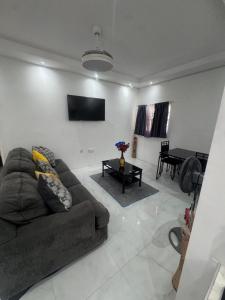 a living room with a couch and a flat screen tv at Faith moves mountains in Ocho Rios