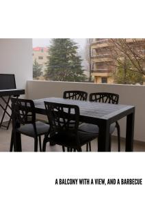 a balcony with a table and chairs and a laptop at Domaine De Faraya F2 in Nab‘ al Maghārah