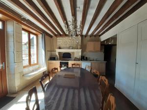 a dining room with a table and chairs in a kitchen at LE SOURCIER in Argançon