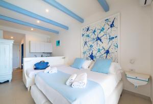 two beds in a white room with blue accents at Residence Le Terrazze in Sorrento +123 photos