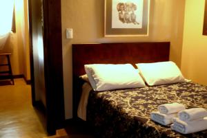 1 dormitorio con 1 cama y 2 toallas plegables. en Posta Chimango, Cabañas frente al Golf Los Acantilados en Mar del Plata