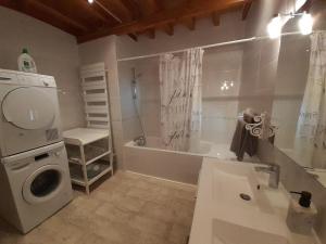 a bathroom with a sink and a washing machine at LE SOURCIER in Argançon +20 photos