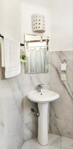 a white bathroom with a sink and a mirror at Casa Mazunte Tierra Viva in Mazunte