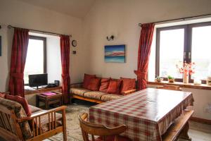 a living room with a table and a couch at Scoor - Garden Cottage in Bunessan