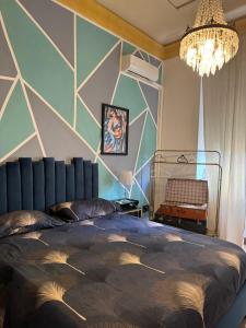 a bedroom with a large bed and a chandelier at Visconti suite and spa in Catania