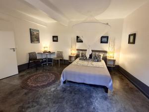 a bedroom with a bed and a table with two chairs at La Case des Caraïbes in Le Gosier