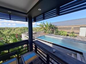 a house with a swimming pool on a balcony at La Case des Caraïbes in Le Gosier