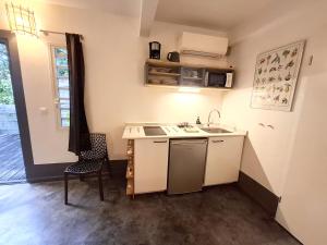 a small kitchen with a sink and a table at La Case des Caraïbes in Le Gosier