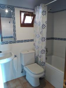 Un baño con inodoro, lavabo y bañera. en Casa Rural Casa Azul, en Villahormes